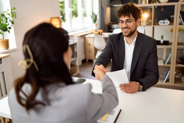 Young Caucasian man handshake with a female recruiter/HR of Japanese ethnicity during job interview