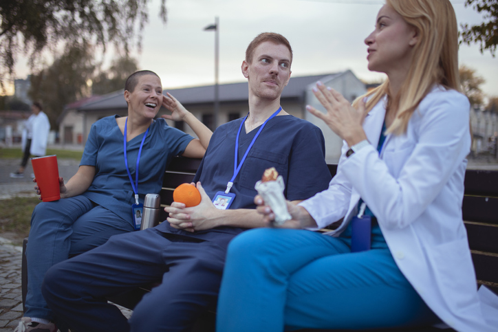 A group of nurses gathering together on a bench