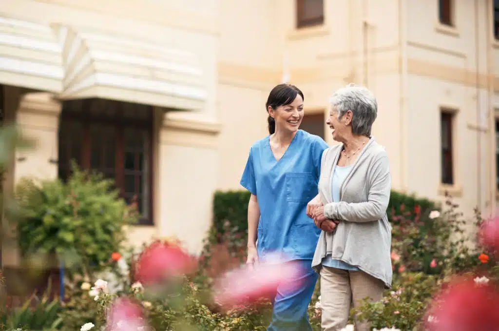 nurse walking outside with female patient